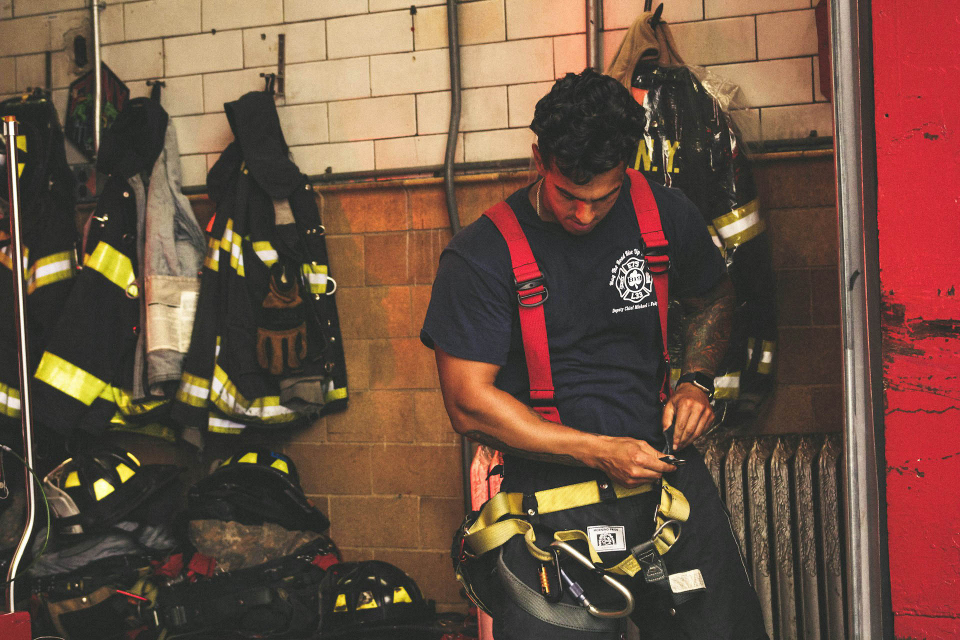A first responder firefighter puts on his gear.