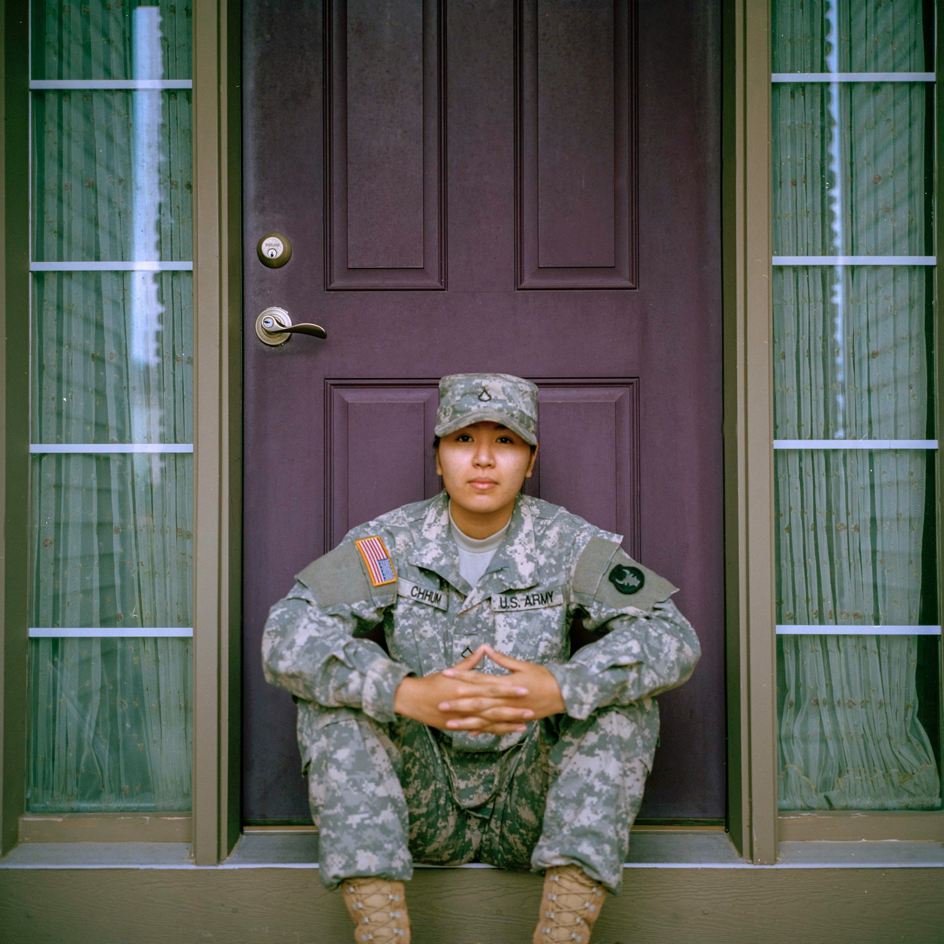 A veteran sits in the doorway and faces the camera.